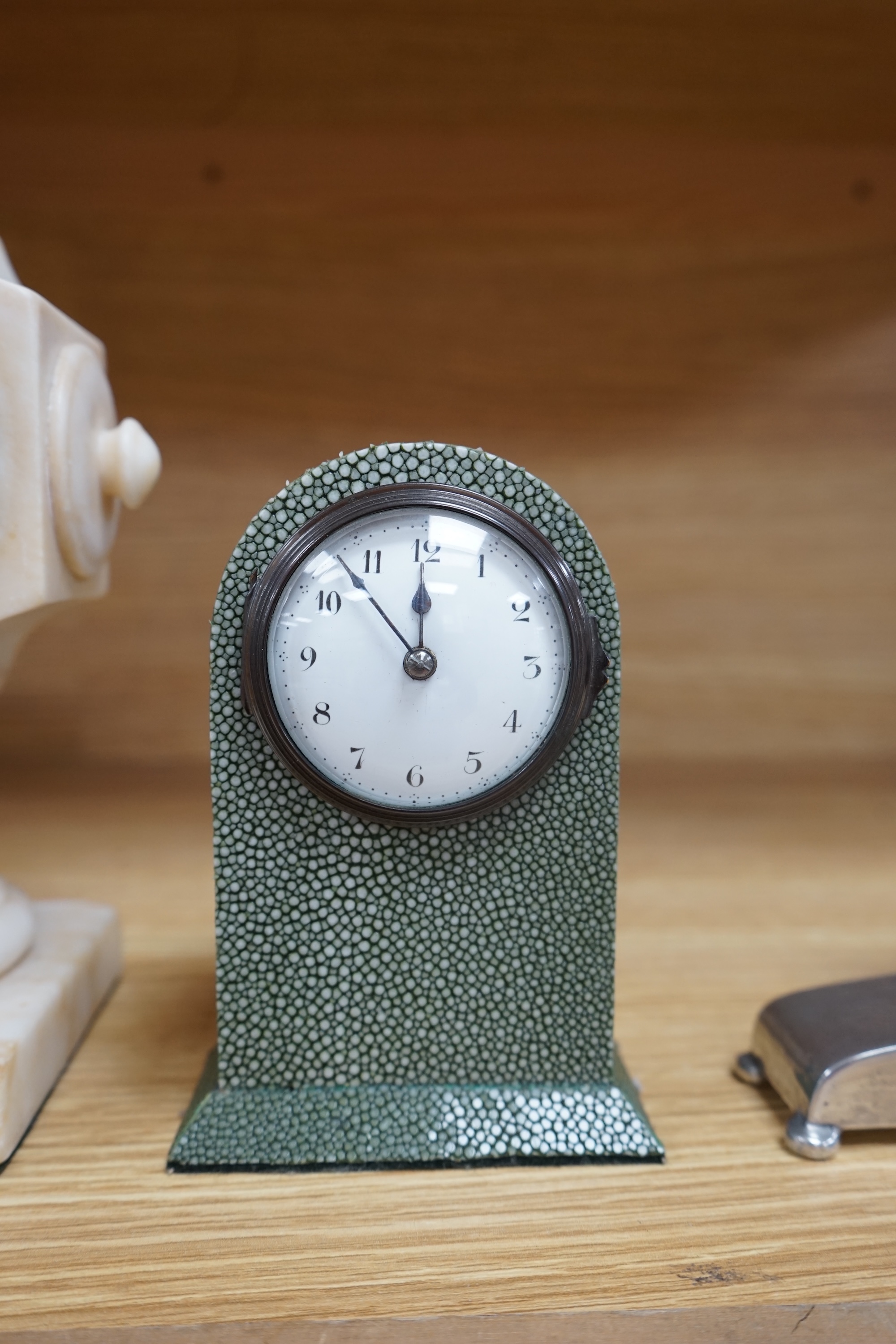 Three small mantel timepieces including a Tudric pewter timepiece, and a French timepiece in an alabaster case, signed Henry Marc, Paris. Condition - fair to good.